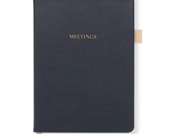 May include: A dark blue leather-bound notebook with a gold ribbon bookmark and the word "MEETINGS" embossed on the front cover.