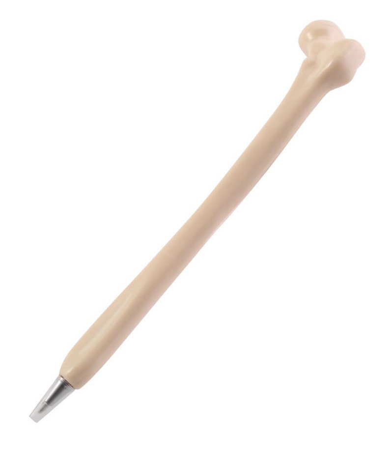 May include: A beige plastic pen shaped like a human bone. The pen has a silver tip and a rounded end.