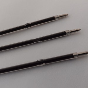 May include: Three black ballpoint pen refills with silver tips.