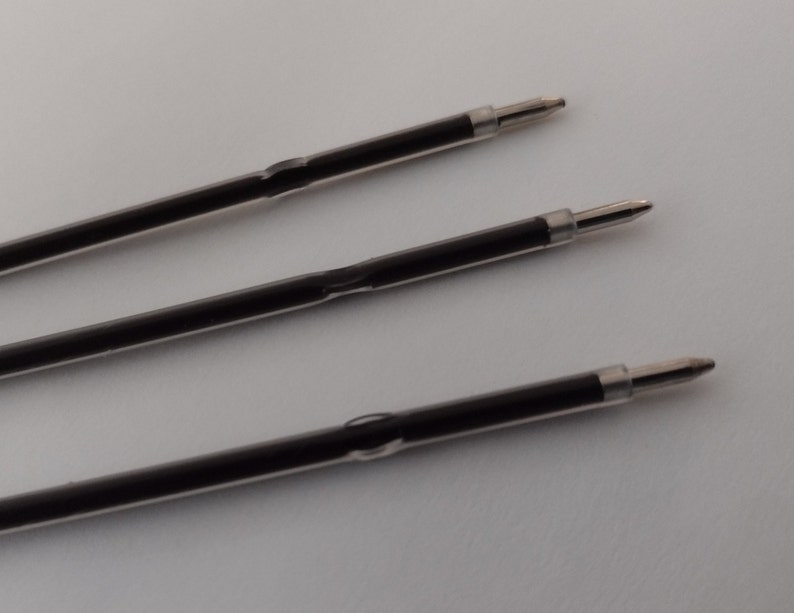 May include: Three black ballpoint pen refills with silver tips.