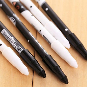 May include: A set of five pens featuring a black and white color scheme with polka dot patterns and cat-themed illustrations. Each pen has a contrasting cap and barrel design, with some barrels displaying the text Kupai KP-1049 and a barcode.