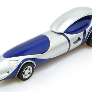 May include: A silver and blue pen shaped like a futuristic race car. The pen has a blue body with a silver top and a silver stripe down the side. The pen has black wheels and a silver tip.