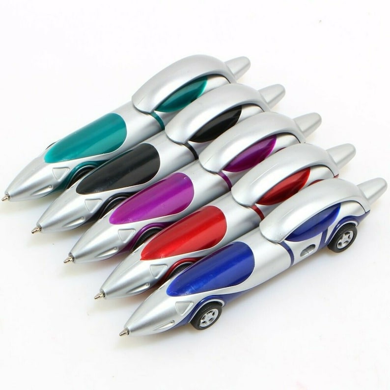 May include: Five silver and colored pens shaped like race cars. The pens have a silver body with a colored stripe and a small car design at the end. The colors are teal, black, purple, red, and blue.