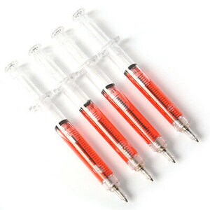 May include: Four clear plastic syringe-shaped pens with red ink. The pens are arranged in a row, with the tips pointing to the right.