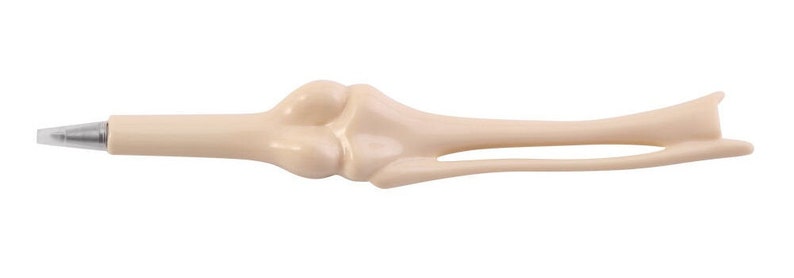 May include: A beige plastic pen shaped like a human bone. The pen has a silver tip and a bone-like design.