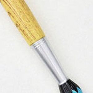 May include: Close-up of a paintbrush with a wooden handle and a silver ferrule. The bristles are black and turquoise. The brush is angled diagonally against a white background.