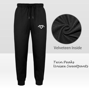 May include: Black unisex sweatpants with a white logo and drawstring waist. The text "Twin Peaks Unisex Sweatpants" is displayed. A close-up shows the velour interior.