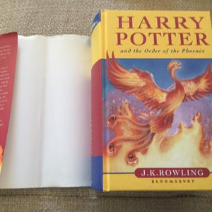 May include: A red, white, and blue book cover with the title "Harry Potter and the Order of the Phoenix" by J.K. Rowling. The cover features a phoenix in flight with a fiery background.