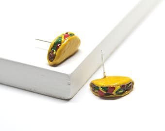 May include: A pair of yellow taco earrings with red and green fillings. The earrings are made of polymer clay and have silver posts.
