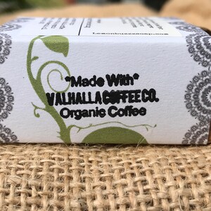May include: A white box with green and gray designs. The box has black text that reads "Made With" "VALHALLA COFFEE CO." "Organic Coffee".