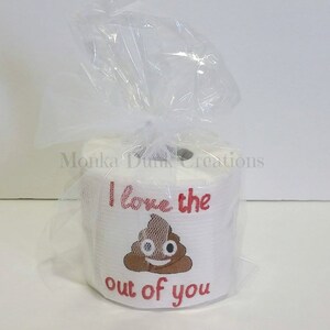 Op de afbeelding: Een witte toiletrol met een rood en bruin ontwerp met de tekst "I love the out of you" en een poep-emoji in het midden.