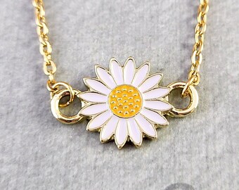 May include: A gold chain necklace with a white and yellow enamel daisy charm.