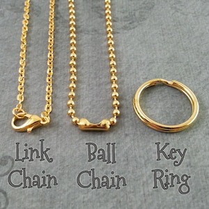 May include: Three gold-colored jewelry findings: a link chain with a lobster clasp, a ball chain, and a key ring. The text below each item reads "Link Chain", "Ball Chain", and "Key Ring".