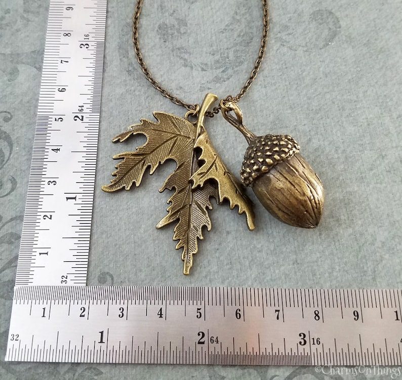May include: A gold tone necklace with an acorn and leaf charm. The acorn is about 1 inch in diameter and the leaf is about 1.5 inches long.