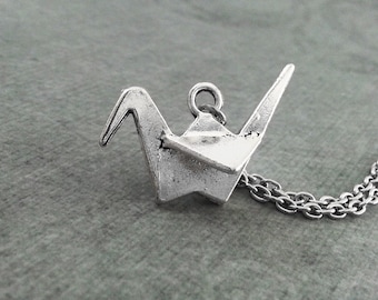 May include: Silver origami crane pendant necklace. The crane is a symbol of peace and good luck.
