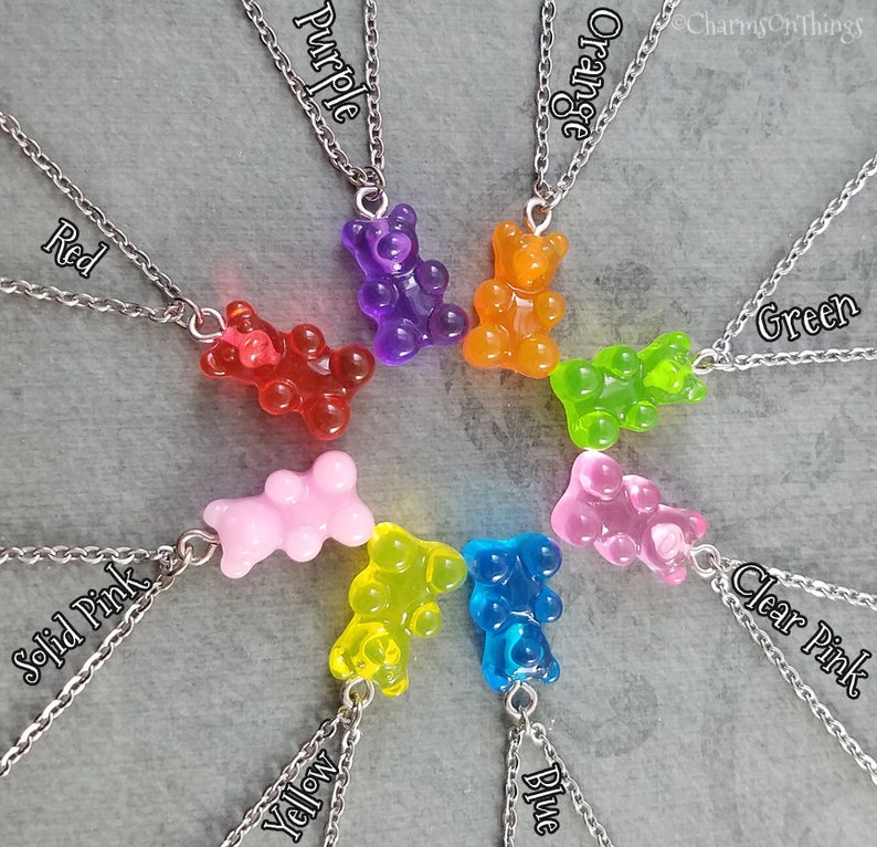 Puede incluir: Un conjunto de ocho collares de ositos de gominola, cada uno de un color diferente: rojo, naranja, amarillo, verde, azul, morado, rosa s&oacute;lido y rosa transparente. Cada collar tiene una cadena plateada y un colgante de osito de gominola.