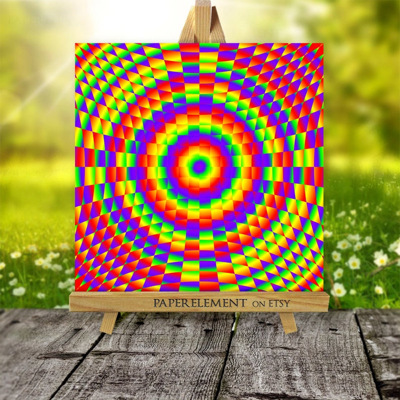 K&ouml;nnte beinhalten: Ein farbenfroher abstrakter Kunstdruck mit einem regenbogenfarbenen Karomuster und einem zentralen Kreis. Der Druck wird auf einem Holzstaffelei pr&auml;sentiert.