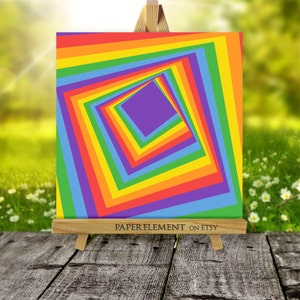 K&ouml;nnte beinhalten: Ein quadratisches Bild mit einem Regenbogenmuster, in dessen Mitte sich ein violettes Quadrat befindet. Das Regenbogenquadrat besteht aus mehreren Quadraten, die jeweils eine andere Farbe des Regenbogens haben. Das Bild befindet sich auf einem Holzstaffelei mit dem Text "PAPERELEMENT ON ETSY" am unteren Rand.