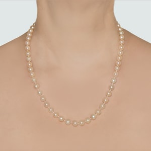 May include: A classic pearl necklace with a simple design. The necklace is made of white pearls and is strung on a silver chain.