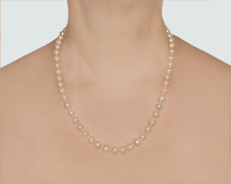 May include: A classic pearl necklace with a simple design. The necklace is made of white pearls and is strung on a silver chain.