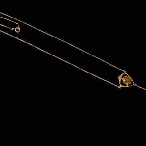 May include: A gold chain necklace with a teardrop pendant and a geometric design featuring a round, yellow gemstone.