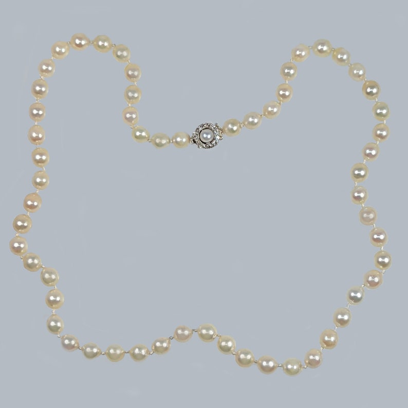 May include: A white pearl necklace with a silver clasp. The necklace is made of small, round pearls and has a simple design.