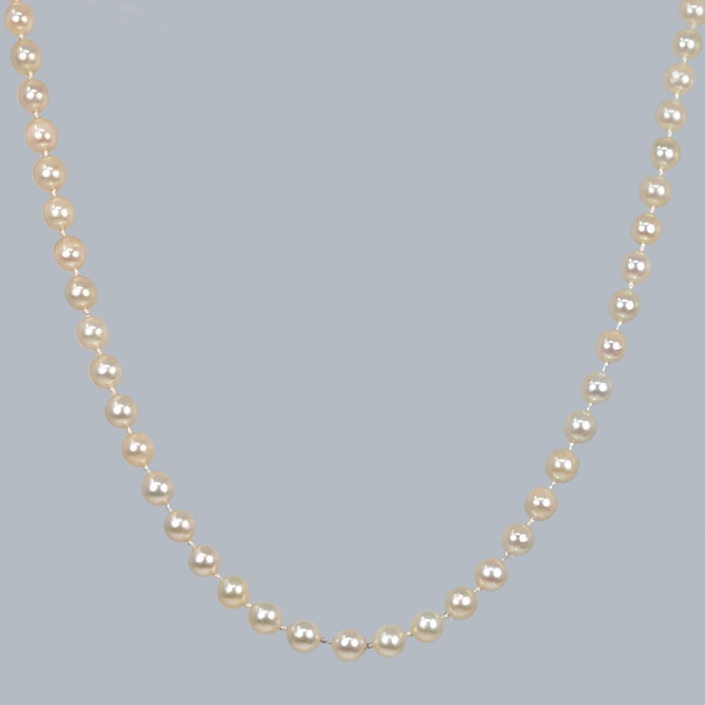 May include: A strand of white pearls strung together on a silver chain.
