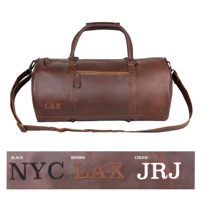 May include: Brown leather duffel bag with a shoulder strap and top handles. The bag has a zippered pocket on the front and the text "LAX" is embroidered on the side.