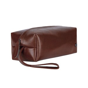 Puede incluir: Una bolsa de viaje de cuero marr&oacute;n con cierre de cremallera y asa. La bolsa est&aacute; hecha de cuero de alta calidad y tiene un dise&ntilde;o cl&aacute;sico.
