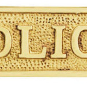 May include: A rectangular brass sign with the words "NO SOLICITING" in bold, raised letters. The sign has a textured background and decorative edges, with holes for mounting.