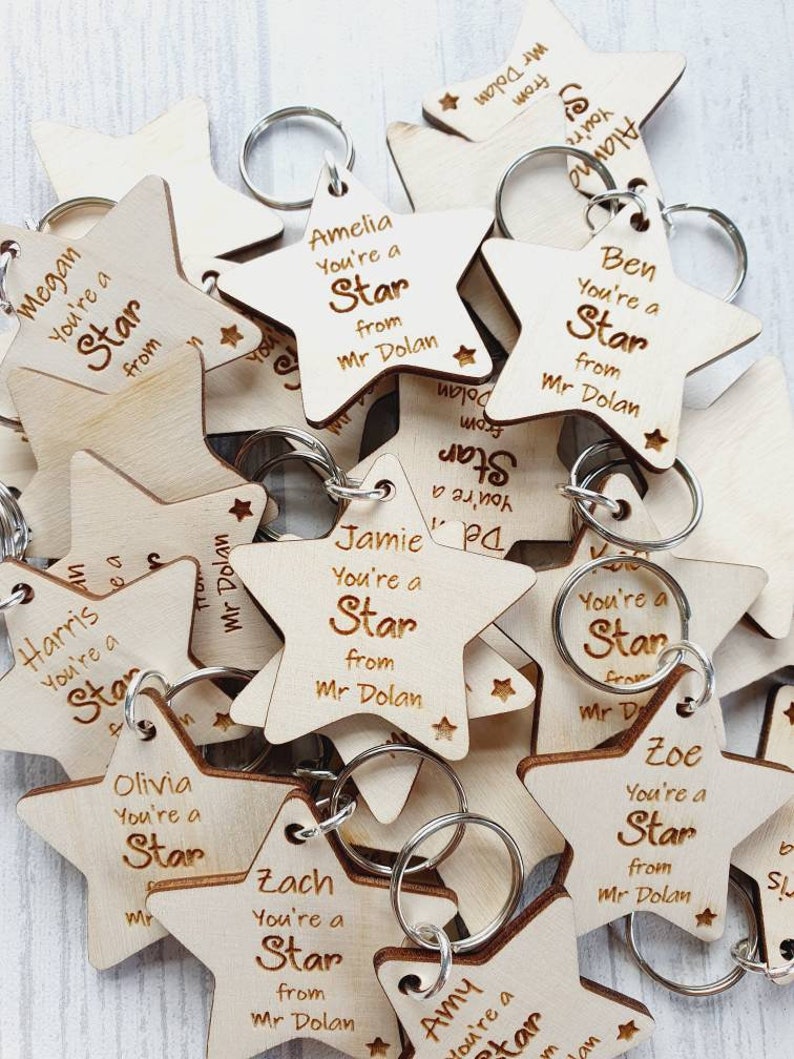 Peut inclure: Un ensemble de porte-cl&eacute;s en forme d'&eacute;toile en bois avec le texte "You're a Star from Mr. Dolan" et un nom diff&eacute;rent sur chaque porte-cl&eacute;s.