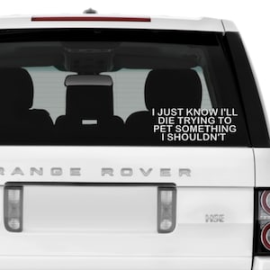 May include: White car rear window with a decal that reads "I JUST KNOW I'LL DIE TRYING TO PET SOMETHING I SHOULDN'T." The car is a Range Rover, with the word "RANGE ROVER" across the back.