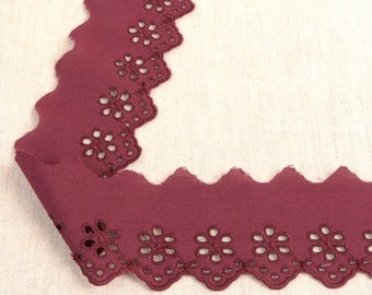 May include: Burgundy cotton lace trim with a scalloped edge and a floral cut-out design.