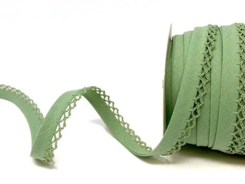 May include: A roll of sage green elastic trim with a delicate crochet edge. The trim is approximately 1 inch wide.