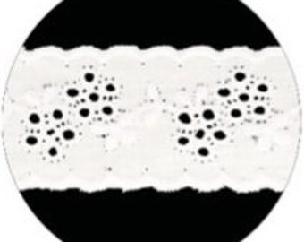 Peut inclure: Gros plan sur un ruban de dentelle blanc avec un bord festonné et un motif répétitif de petits points sombres. La dentelle est posée sur un fond circulaire noir, soulignant sa texture et son design délicats.