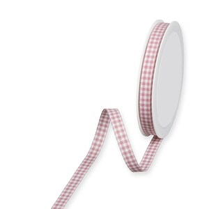 Könnte beinhalten: Eine Spule mit rosa-weißem Gingham-Band. Das Band ist um eine weiße Spule mit einem weißen Etikett gewickelt.