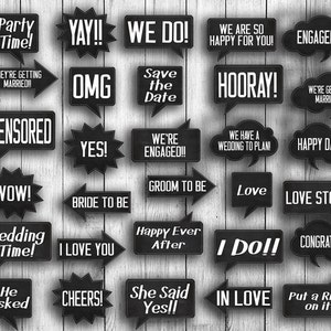 May include: A collection of black speech bubbles and signs with white text on a light wood background. Phrases include "Party Time!", "We Do!", "Engaged!!!", "Save the Date", and "I Love You".