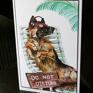 May include: A watercolor illustration of a German Shepherd dog wearing headphones and sunglasses, relaxing on a lounge chair with a drink in its paw. A sign reads "Do Not Disturb".