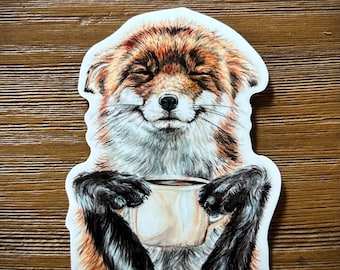May include: A sticker featuring a cartoon fox with closed eyes, a smile, and holding a coffee mug with both paws.