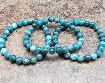 Könnte beinhalten: Drei blaue Edelstein-Armbänder mit runden Perlen. Die Armbänder sind aus blauen Apatitsteinen gefertigt.