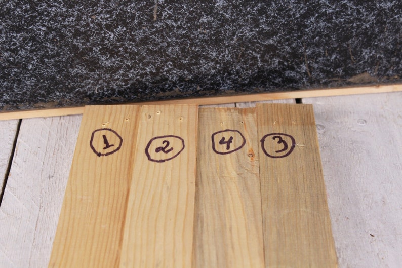 May include: Four wooden planks with numbers 1, 2, 3, and 4 circled in black marker.
