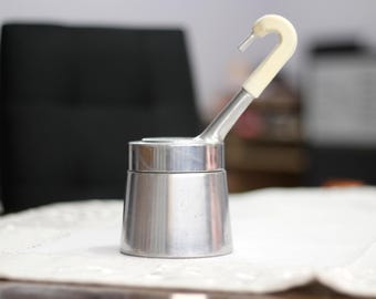 May include: A silver and white stovetop espresso maker with a swan-shaped handle.