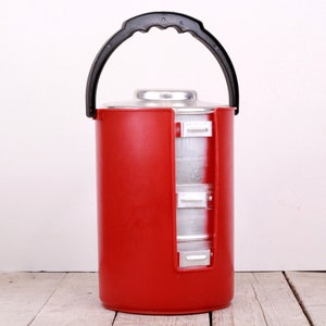 May include: A red insulated food carrier with a black handle and multiple stainless steel containers inside.