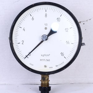 Può includere: Un manometro bianco e nero con un ago nero che punta a 1,5 kgf/cm². Il manometro legge da 0 a 16 kgf/cm² e ha il testo "ΜΤΠ-160" e "CCCP" stampato sul quadrante. Il manometro è datato 1986 e ha il numero di serie "No 4231515".