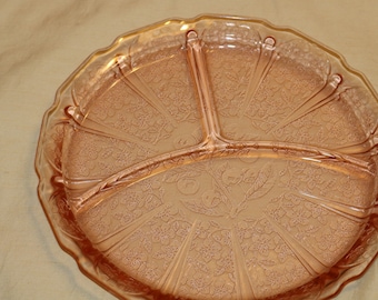 May include: A pink glass divided serving dish with a floral pattern. The dish has four sections and a scalloped edge.