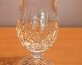 May include: A clear glass goblet with a cut crystal design. The goblet has a wide bowl and a short stem with a flared base.