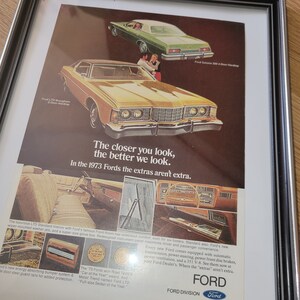May include: A vintage advertisement for 1973 Ford cars. The ad features a yellow Ford LTD Brougham 2-Door Hardtop and a green Ford Galaxie 500 4-Door Hardtop. The text reads "The closer you look, the better we look. In the 1973 Fords the extras aren't extra."