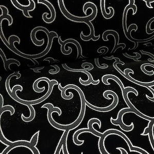 以下が含まれることがあります： 渦巻き状の花柄が銀色で描かれた黒い布地