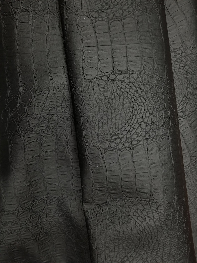 Peut inclure: Tissu en simili cuir noir avec un motif gaufr&eacute; crocodile.