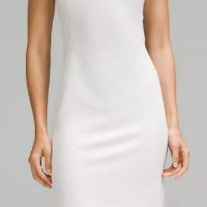 May include: A white sleeveless dress with a round neckline. The dress is made of a ribbed fabric and has a fitted silhouette.